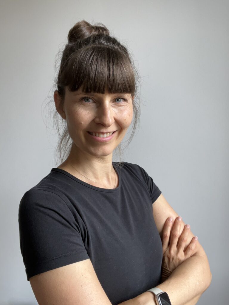 Porträt von Shireen Predehl mit verschränkten Armen vor grauer Wand