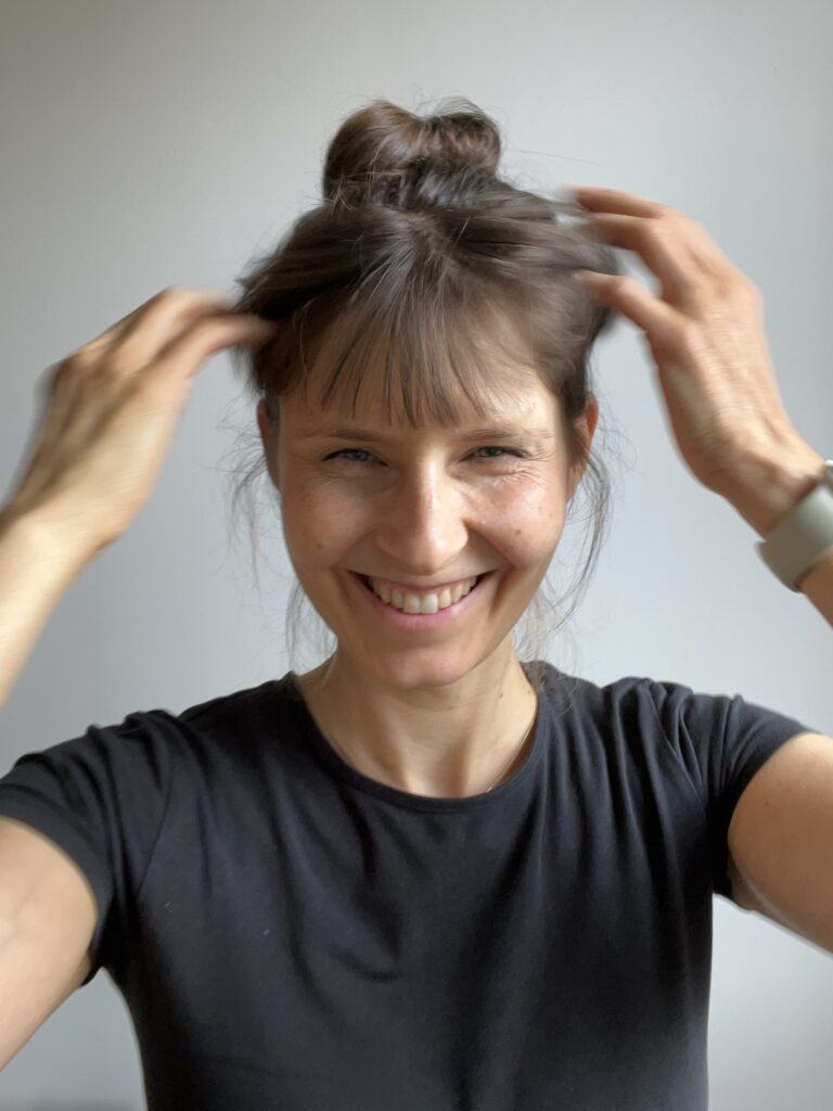 Shireen fasst sich lachend mit beiden Händen in die Haare