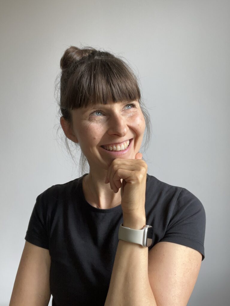 Shireen stützt neugierig lächelnd das Kinn in die Hand
